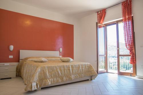 a bedroom with a bed and a large window at Agriturismo L'Oasi in Ceraso
