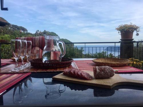 a table with wine glasses and food on a balcony at Splendid Villa Sea View Alassio in Alassio
