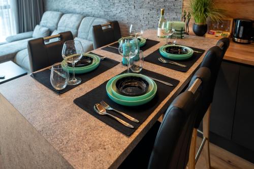 a table with plates and wine glasses on it at Apartment Luxury Vision in Varna City