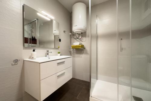 a white bathroom with a sink and a shower at Stay Barcelona Sant Antoni in Barcelona