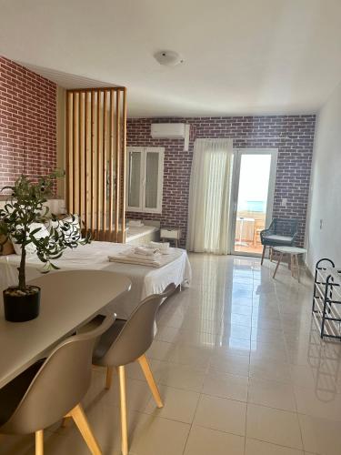 a dining room with a table and chairs and a room with at Nautica Hotel Apartments in Stavromenos