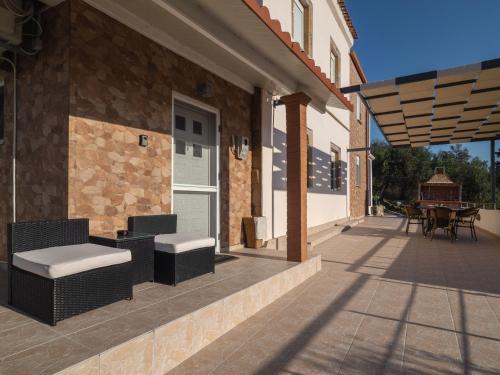 a patio with chairs and a table on a building at Olea Stone House near the sea in Nótos