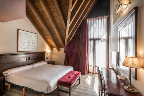 een slaapkamer met een bed, een tafel en een bureau bij Snö Villa de Sallent 4 in Formigal