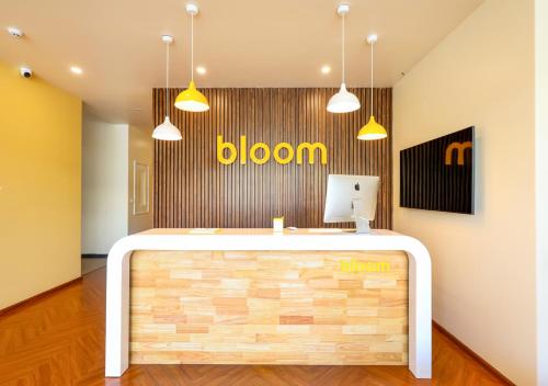 a reception desk with a brown sign on a wall at Bloom Hotel - Golf Course Road, Sector 43 in Gurgaon