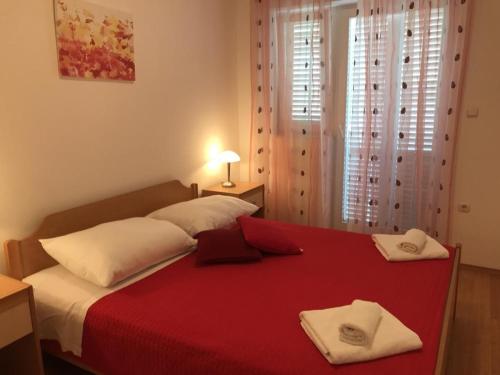 a red bed with two towels on top of it at Apartment in Zaboric with sea view, balcony, air conditioning 5178-3 in Šibenik
