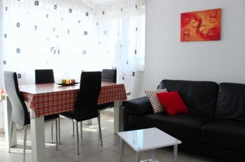 a living room with a black couch and a table at Apartment in Zaboric with sea view, balcony, air conditioning, WiFi 5178-2 in Šibenik