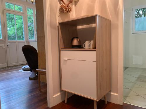 a cabinet in a living room with a table at Suite privative Abella - Aile de maison bourgeoise in Ambarès-et-Lagrave
