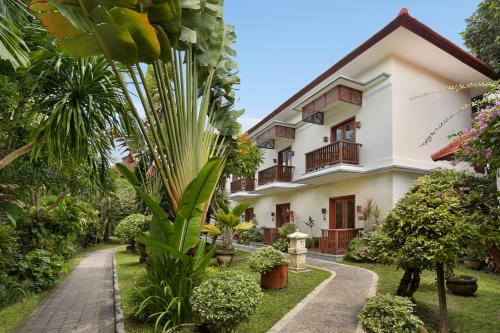 a house with a garden in front of it at Respati Beach Hotel in Sanur