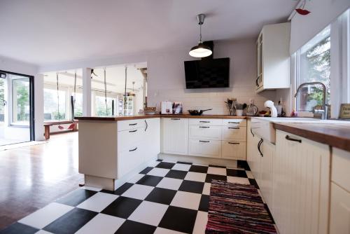 una cocina con suelo a cuadros en blanco y negro en Spacious 3 Bedroom Family Oasis with Sauna, 20 min from Warsaw en Piaseczno