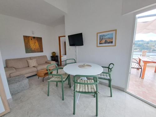 a living room with a table and chairs and a couch at Villa Porto in Rogač