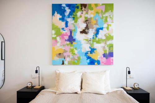 a bedroom with a bed and a painting on the wall at Modern Downtown 1 BR Apartment in Reykjavík