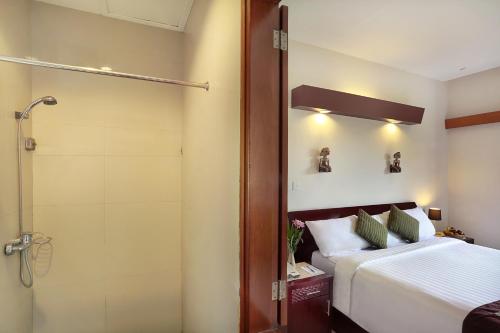 a bedroom with a shower and a bed and a shower at Respati Beach Hotel in Sanur