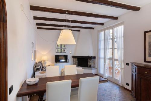 a dining room with a table and white chairs at Apartment Merida in Belgirate