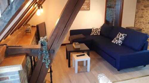 uma sala de estar com um sofá azul e uma mesa em Appartement climatisé avec vue sur les Remparts, centre de Rocroi, parking privatif et garage vélos em Rocroi