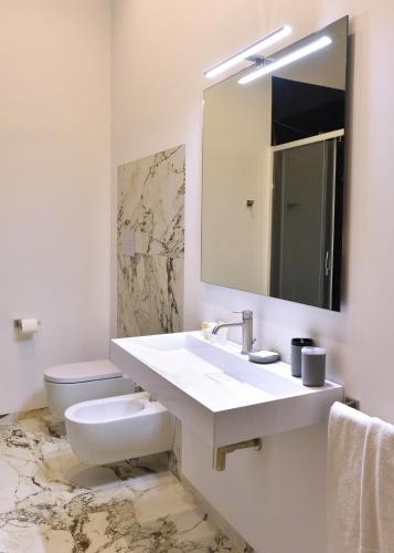 a bathroom with a sink and a toilet and a mirror at Hotel Exclusive in Agrigento