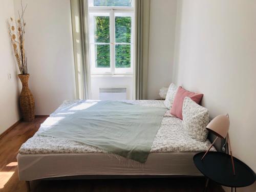 een slaapkamer met een groot bed met roze kussens bij Adam&Eva Rooms in Praag