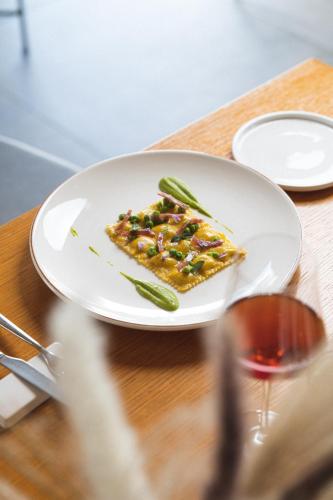 a plate of food on a table with a glass of wine at i Cacciagalli Wine Resort in Teano