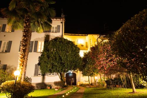 a large white building with a palm tree at night at Antica Casa Balsari in Borgo Ticino