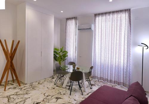 a living room with a table and chairs and curtains at Hotel Exclusive in Agrigento