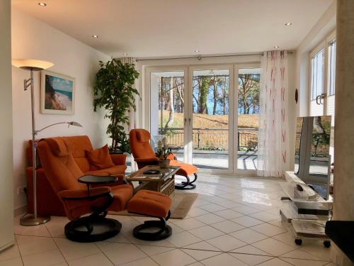 ein Wohnzimmer mit orangefarbenen Stühlen und einem TV in der Unterkunft Villa Marfa - FeWo 03 in Bansin