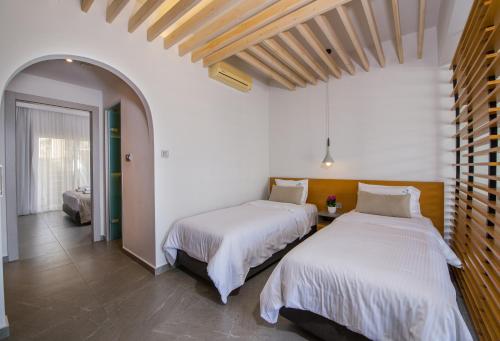 two beds in a room with white walls at Balos Beach in Kissamos