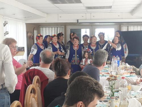grupa ludzi pozujących do zdjęcia przy stole w obiekcie Hotel plutitor Sofia-Maria w mieście Uzlina
