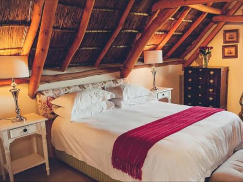 a bedroom with a large bed and two lamps at De Kleijne Bos in Paarl