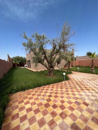 a brick driveway with a tree in a yard at Villa privative tortues2 piscine chauffée 35min Marrakech in Marrakech