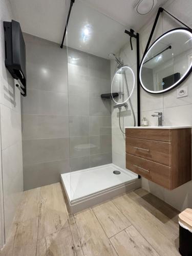 a bathroom with a shower with a sink and a mirror at L'évasion des pins - Au coeur de la Nature in Saint-Jean-de-Monts