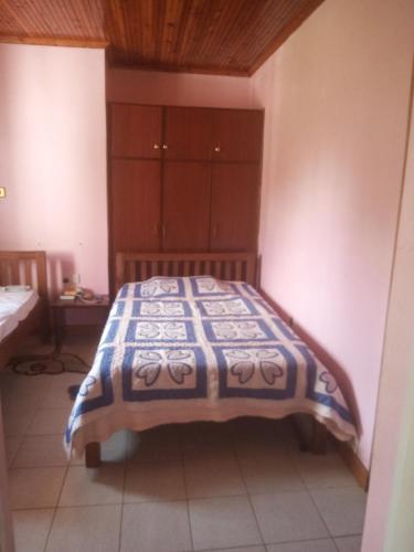 1 dormitorio con 1 cama con manta azul y blanca en Key's Place en Ambira