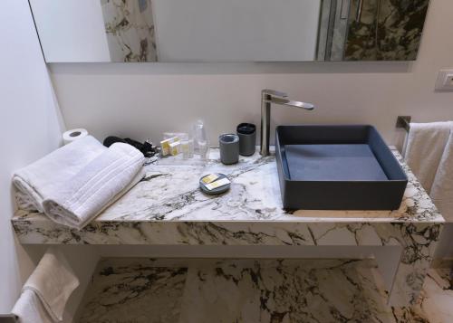 a bathroom counter with a sink and a mirror at Hotel Exclusive in Agrigento