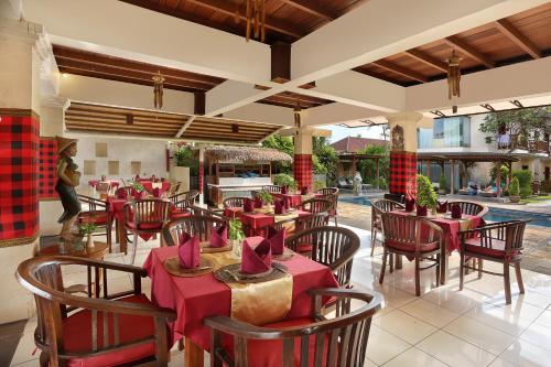 a restaurant with tables and chairs with red tablecloths at Respati Beach Hotel in Sanur