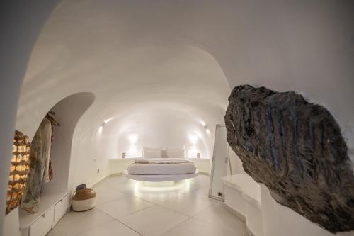 um quarto com uma cama num quarto branco em Luxus VIP Suites em Oia