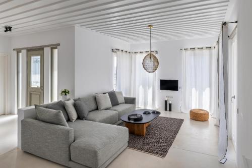 a living room with a couch and a table at Syros Grace eco-Villa with Jacuzzi & Stuning Views in Ano Syros