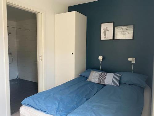 a bed in a bedroom with a blue wall at Cozy apartment in Hafjell - Øyer centre in Hafjell