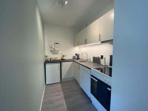 una cocina con armarios blancos y electrodomésticos azules en Apartment in Hafjell / Øyer centre. en Hafjell
