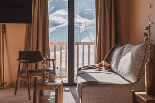 a living room with a chair and a window with a view at La Voie Lactée in La Mongie