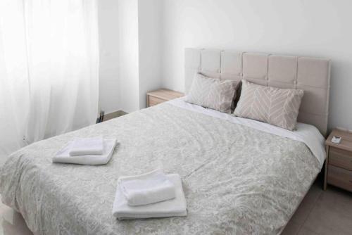 een slaapkamer met een groot bed en 2 handdoeken bij Modern spacious apartment located in Piraeus (B8) in Piraeus