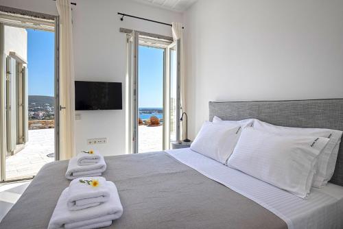 a bedroom with a large bed with towels on it at Syros Grace eco-Villa with Jacuzzi & Stuning Views in Ano Syros