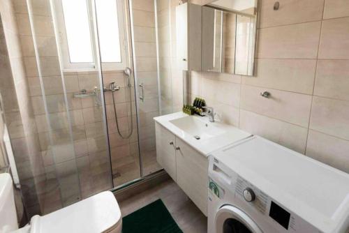 een badkamer met een wasmachine en een wastafel bij Modern spacious apartment located in Piraeus (B8) in Piraeus