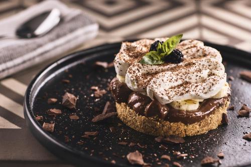 a dessert with chocolate and whipped cream and a mint leaf on a plate at Xenia Residence & Suites in Pili