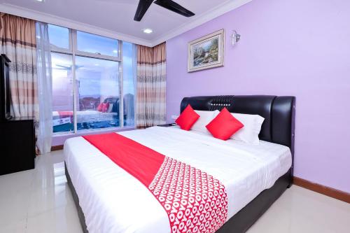 a bedroom with a large bed with red pillows at OYO 714 Arina Hotel in Bangi