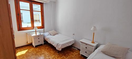 a bedroom with two beds and a window at Somos Mar in Pamplona