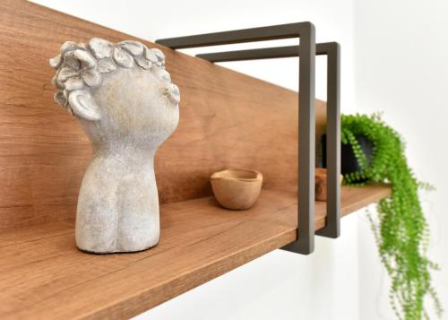a statue sitting on a wooden shelf next to a plant at Hotel Exclusive in Agrigento