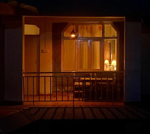 an open door to a balcony at night at Himtrek Stays,Mcleodganj in McLeod Ganj