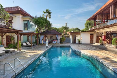 a swimming pool in front of a house at Respati Beach Hotel in Sanur
