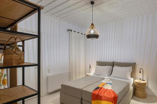 a white bedroom with a bed and a shelf at Syros Grace eco-Villa with Jacuzzi & Stuning Views in Ano Syros