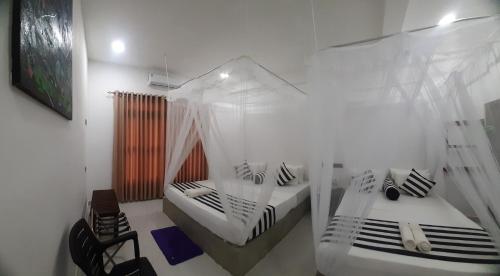 a bedroom with two beds with mosquito nets at Anuradhapura Kingdom View Resort in Anuradhapura