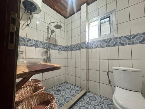 bagno con servizi igienici e finestra. di appartements meublés à Logbessou a Douala