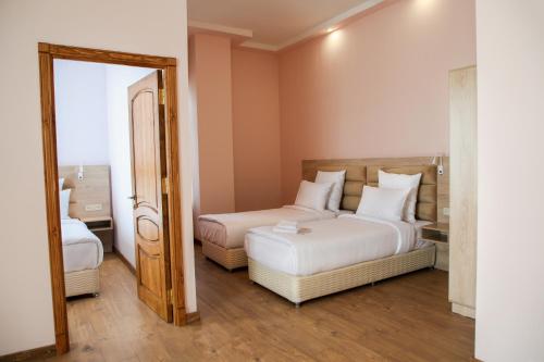a bedroom with two beds and a mirror at KUMA Hotel Gyumri in Gyumri